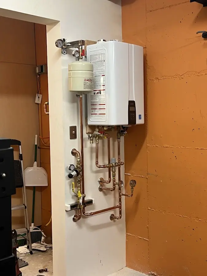 Plumbing technician inspecting water heater connections in Meridian